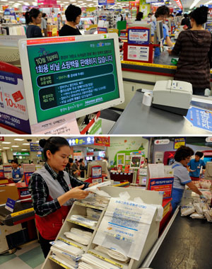 27일 대구시내 한 대형마트 계산대 모니터에 일회용 비닐봉투 판매 중단을 알리는 화면이 공지되고 있다.(위) 계산대에는 일회용 비닐봉투 대용으로 