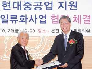 ▲민계식(왼쪽) 현대중공업 회장과 김도연 울산대 총장이 협정서에 서명한 뒤 악수를 나누고 있다.