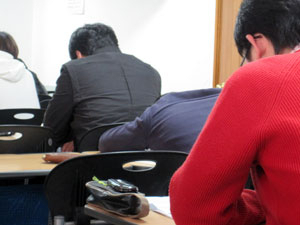 한 대학 교수가 영어로 물리학 이론을 설명하고 있지만 학생들은 잠을 자거나 딴짓을 하는 등 수업에 집중하지 않고 있다.