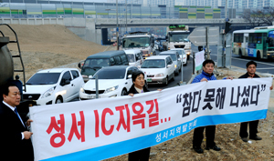 도시고속도로 교통체증 문제가 해결되지 않자 대구 달서구 성서지역 주민들이 22일 오전 성서IC주변 도로 곳곳에 주민들의 불만을 토로하는 현수막을 내걸고 있다. 현수막 뒤쪽으로 출근 차량들이 성서IC 진입을 위해 장사진을 이루고 있다. 이채근기자 mincho@msnet.co.kr