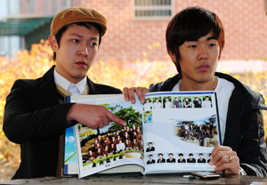 24일 오후 북한의 연평도 포격으로 부상당한 대구 출신 이민욱 일병의 친구 이재형(왼쪽)·박대규 씨가 이 일병과 함께 찍은 고등학교 졸업앨범 사진을 보여주며 부상이 하루빨리 완쾌되기를 바라고 있다 . 성일권기자 sungig@msnet.co.kr