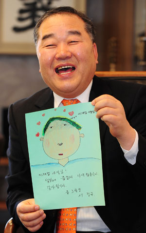 이재업 대표가 특수학교인 안동 영명학교 도촌분교 학생들이 보내온 감사의 편지를 들고 환하게 웃고 있다.