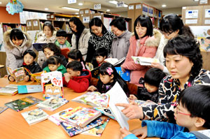 성당하늘채도서관 김민숙 봉사회장(오른쪽 두 번째)과 회원 및 아동들이 모여 도서를 열람하고 있다. 이채근기자 mincho@msnet.co.kr