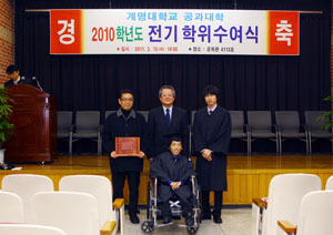 근이양증 판정 후 지체장애 1급의 몸이 된 고강민(24·앞줄 가운데) 씨가 15일 열린 계명대 학위수여식에서 수석졸업자로 총장상을 수상, 인간승리의 모습을 보여줬다. 뒷줄 왼쪽부터 부친 고경환 씨, 공대학장 배석천 교수, 도우미 학생 곽준영 씨.
