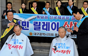 동남권 신공항 밀양유치를 기원하는 삭발 릴레이에 시민들도 참여하고 있다. 이기운(오른쪽·낙동애국회 대표), 정병택(동구 효목동) 씨가 21일 오전 대구시의회 현관 앞에서 삭발하고 있다. 이채근기자 mincho@msnet.co.kr