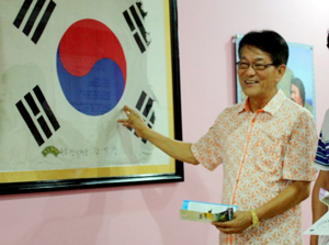 캄보디아 독도홍보관을 건립한 김정욱 씨가 전시실에 걸린 태극기에 대해 설명하고 있다. 독도홍보관 제공