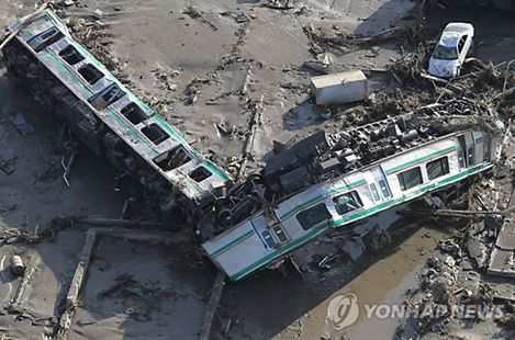 일본 동북부 지방을 강타한 지진으로 피해가 확산되는 가운데 12일 후쿠시마현 신치마치 인근에서 전동차가 뻘밭에 뒹굴고 있다.