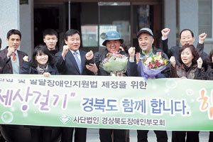 ▲발달장애를 앓고 있는 이균도 군과 아버지 이진섭 씨가 이달 12일 부산을 출발해 24일 구미시청에 도착, 김재홍 구미부시장 및 장애인단체 회원들과 기념촬영을 하고 있다.
