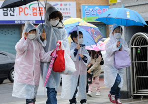 7일 오전 방사능 비에 대한 우려감이 높아지면서 대구 시내 한 초등학교에서 어린이와 어머니가 마스크와 비옷을 착용한 채 등교하고 있다. 우태욱기자 woo@msnet.co.kr