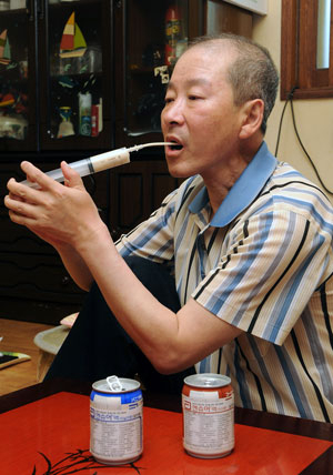 설암으로 투병중인 이민영 씨가 식사대용으로 주사기에 담은 영양액을 빨아먹고 있다. 김태형기자 thkim21@msnet.co.kr