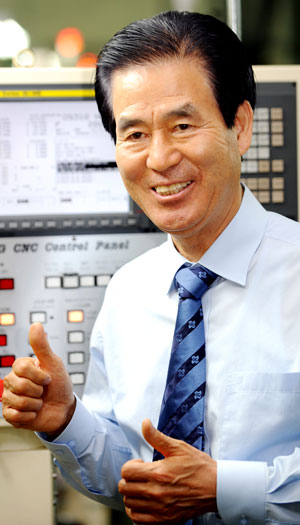 정태일 회장이 절삭공구를 만드는 1층 공장에서 정밀한 절삭공구가 생산되는 라인에 대해 설명하고 있다.