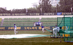 10일 오후 대구시민야구장에서 열릴 예정이던 삼성-두산전을 앞두고 갑자기 비가 내리자 삼성 관계자들이 그라운드에 방수포를 덮고 있다. 삼성 라이온즈 제공