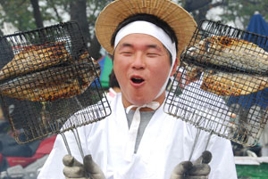 숯불에 노릇노릇 잘 구운 안동간고등어를 들고 있는 안동간고등어 직원.