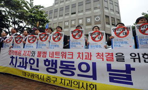 29일 대구 중구 치과의사회원들이 유디치과가 입점해 있는 대구시 중구 대우빌딩앞에서 유디치과그룹의 의료상품화가 국민건강을 위협한다고 주장하며 시위를 벌이고 있다. 김태형기자 thkim21@msnet.co.kr