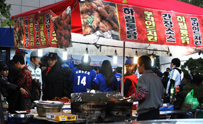 26일 한국시리즈 2차전이 열린 대구시민야구장 주변 상가에 치킨 등 간식거리를 사려는 시민들이 줄을 잇고 있다. 우태욱기자 woo@msnet.co.kr