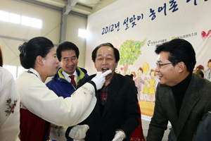 한 결혼이민여성이 서규용 장관의 입으로 즉석에서 만든 인절미를 넣어주고 있다.