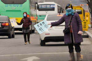 23일 대구대 경산캠퍼스 정문 인근에서 원룸과 하숙집 주인들이 학교 셔틀버스나 시내 버스가 지날 때 마다 팻말을 흔들며 학생들의 입주 호객 행위를 하고 있다. 우태욱기자 woo@msnet.co.kr