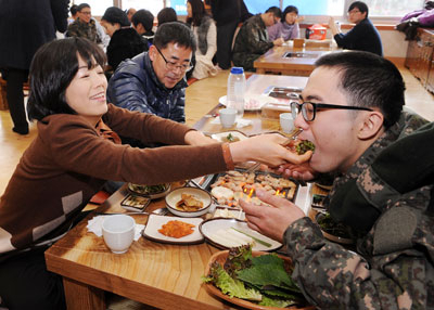 훈련을 끝낸 아들에게 상추에 삼겹살을 싸서 먹여주는 어머니. 