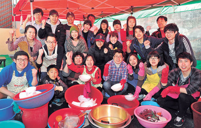 ▲3년 6개월째 매월 첫째 주 일요일 점심식사 봉사를 하는 세 가족과 성 안드레아 성당 소속 청년회, 고교생 자원봉사자들이 점심식사가 끝난 뒤 설거지대 앞에서 파이팅을 외쳤다.