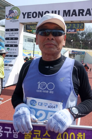 마라톤 풀코스 400회 완주를 달성한 전용구 씨가 마라톤 클럽 회원들의 환영을 받고 즐거워하고 있다.
