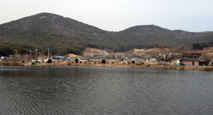 마을 입구 연못에서 바라본 가일마을. 마을 뒤 정산(井山)이 학의 형상으로 마을을 품고 있는 가운데 병곡종택과 수곡고택이 자리하고 있다.