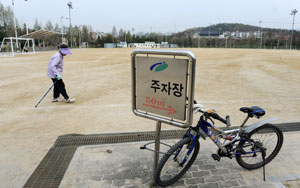 18일 대구 북구구민운동장에서 글자가 떨어져 나간 주차장 안내표시판에 자전거가 매여 있다. 성일권기자 sungig@msnet.co.kr