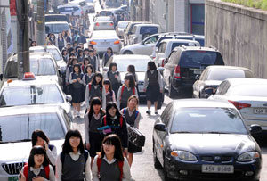 3일 오전 대구 수성구 소선여중 학생들이 학교 앞 인도가 없는 이면도로에서 지나는 차량 사이로 등교하고 있다. 정운철기자 woon@msnet.co.kr