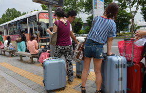 대구를 비롯한 전국 택시 업계가 LPG 가격 인하 등을 요구하며 24시간 운행 중단에 돌입한 20일 오전 대구국제공항 앞 버스승강장에서 여행객들이 많은 짐 보따리를 가지고 버스를 기다리고 있다. 성일권기자 sungig@msnet.co.kr