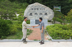 경북과 충북의 경계인 저수령에서 서로 악수를 하고 있는 예천군 상리면 용두리 안성규(58) 씨와 단양군 대강면 올상리 김상섭(58) 씨.