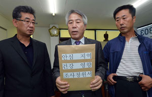 안심지역 비산먼지 대책위원회가 18일 안심연료단지 피해 주민 35명의 건강영향조사를 촉구하는 청원서를 환경부에 제출하기 위해 서울로 출발하면서 청원서를 들어 보이고 있다. 김태형기자 thkim21@msnet.co.kr