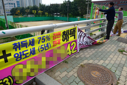 대구 동구청 직원들이 동구 각산동 주택가 도로에 설치된 불법 현수막을 철거하고 있다. 우태욱기자 woo@msnet.co.kr