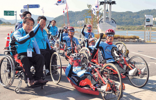 부산에서 서울까지 국토종단에 나선 국가유공자 1급 중상이용사들이 18일 오전 낙동강 칠곡보에서 휠체어자전거로 출발하며 파이팅을 외치고 있다. 김태형기자 thkim21@msnet.co.kr