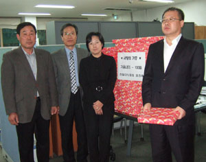 류재발(오른쪽) 씨가 안심1동 주민자치센터에서 저소득 및 독거어르신들에게 내의 100벌을 전달하고 있다.