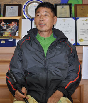 30여 년간 자원봉사 활동을 해 온 양길홍 씨가 그동안 받은 표창장 앞에서 애써 밝은 표정을 짓고 있다. 민병곤기자