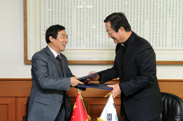 소병욱 대구가톨릭대 총장(사진 오른쪽)과 슝씬원 우한(武漢)과학기술대 부총장이 교류협정을 체결하고 협정서를 교환했다.