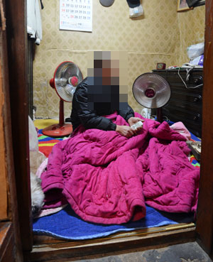 11일 오후 대구 중구 성내동의 쪽방촌에 거주하는 기초생활수급자가 이불을 덮어쓴 채 추위를 피하고 있다. 성일권기자 sungig@msnet.co.kr