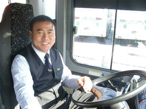 친절한 기사로 알려진 김하곤 씨가 자신의 버스 운전대를 잡고 환하게 웃고 있다.