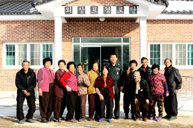 마을회관 부지를 기증한 류재성 거창군 예비군기동대장이 마을 주민들과 함께 신축한 마을회관 앞에서 기념촬영을 했다.