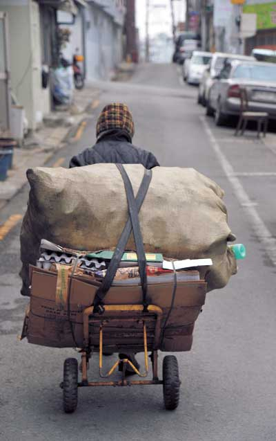 할머니가 일주일 동안 모은 파지를 팔기 위해 고물상으로 향하고 있다. 일주일 동안 애써 모아 판 파지 값은 3천원 정도에 불과하다.