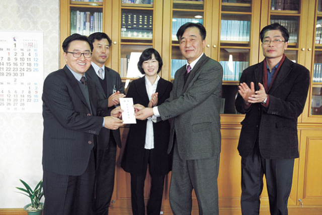 김채해(앞줄 왼쪽) 대구지법 포항지원장 겸 새싹회 회장이 박병선 매일신문 동부지역본부장에게 이웃사랑 성금을 전달하고 있다. 신동우기자