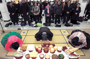 ▲명절에 고향에 가지 못한 사람들이 공동 차례를 지내고 있다. 연합뉴스