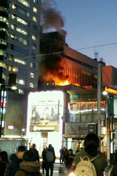 20일 오후 대구 중구 덕산동 동아백화점 쇼핑점이 8층 테라스 의류창고에서 불이 나 화염과 함께 시커먼 연기가 하늘로 치솟고 있다. 퇴근길 시민들이 동성로에서 발길을 멈춘 채 걱정스러운 표정으로 불길을 바라보고 있다. 정운철기자 woon@msnet.co.kr