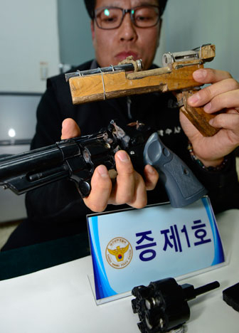 15일 대구남부경찰서에서 경찰관이 피의자 석모 씨로부터 사건 현장에서 빼앗은 사제 총기 2개를 들어 보이고 있다. 우태욱기자 woo@msnet.co.kr