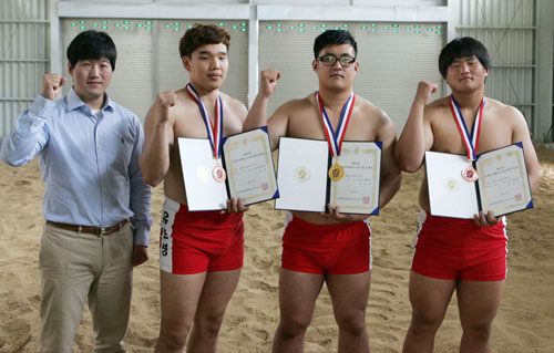 대구대 경산캠퍼스 씨름장에서 최병찬 감독과 유호성, 정덕규, 최재우 선수(왼쪽부터)가 함께 파이팅을 외치고 있다.