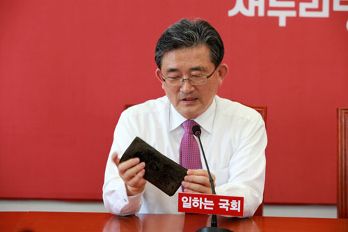이한구 전 원내대표가 40년 전 부인에게서 약혼선물로 받은 오래된 장지갑을 들어 보이고 있다.