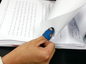 대구지방법원의 한 판사가 파란색 골무를 오른손 엄지손가락에 끼고 기록을 검토하고 있다. 이호준기자