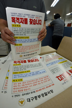대구 여대생 피살 사건을 수사하고 있는 경찰이 신고 포상금 1천만원을 내걸고 피해자가 탄 택시 행방을 찾고 있는 가운데 30일 대구 중부경찰서 형사가 택시업계에 배포할 전단을 정리하고 있다. 우태욱기자 woo@msnet.co.kr
