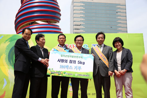지난달 30일 서울 청계천광장에서 열린 칠곡군 농산물 직거래 장터에서 김진천(왼쪽에서 세 번째) 칠곡군참외발전연구회장, 백선기(〃네 번째) 칠곡군수, 이완영(〃다섯 번째) 국회의원이 칠곡군 참외농민들이 기부한 참외 186상자를 서울시 관계자들에게 전달하고 있다. 칠곡군 제공