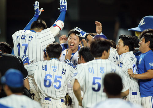 7일 대구시민야구장에서 열린 삼성-두산전에서 삼성 채태인이 9회 말 끝내기 홈런을 친 후 홈에서 기다리고 있던 동료의 축하를 받고 있다. 삼성 라이온즈 제공