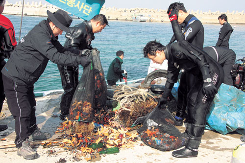 포스코 클린오션 봉사단원들이 바다 밑에 가라앉아 있는 해양오염물질들을 수거하고 있다. 봉사단은 매주 자체 수중정화와 매년 2회씩 민